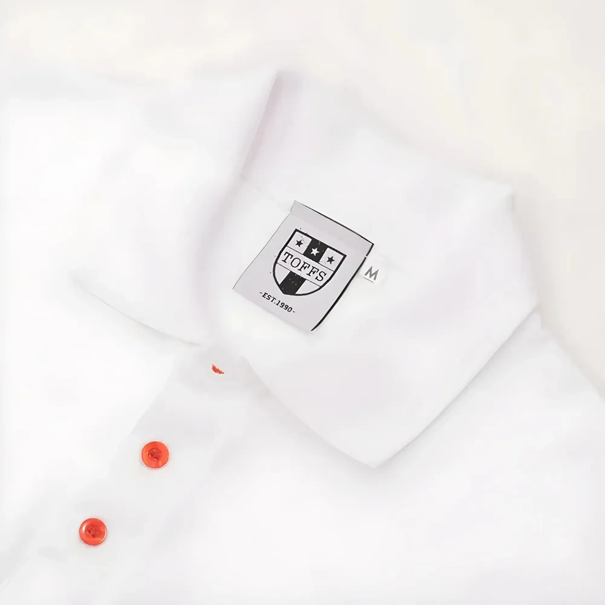 Regular Fit. Embroidered badge. Ribbed collar. Three-button placket. Short sleeves with ribbed armba